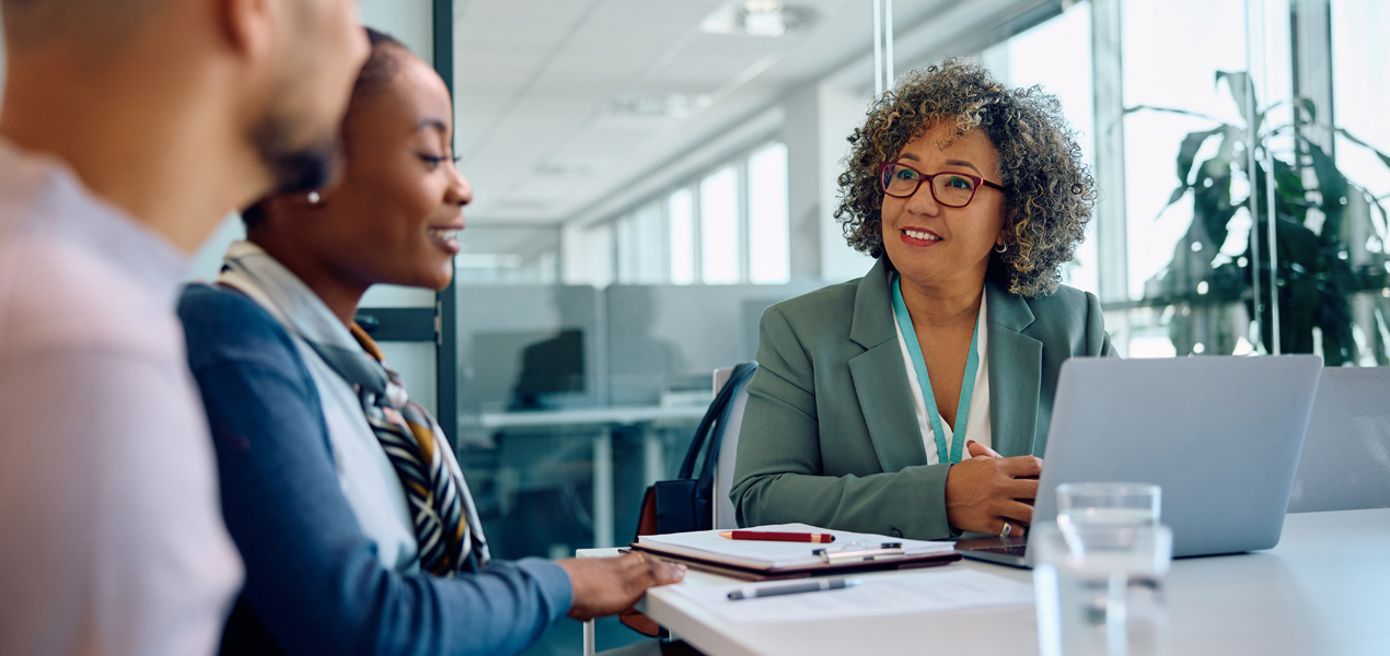 Femme d’affaires rencontrant un couple dans un bureau.