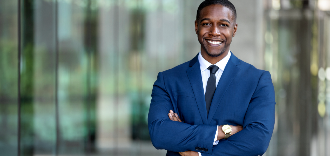 Homme souriant à la caméra en costume bleu, regardant la caméra.