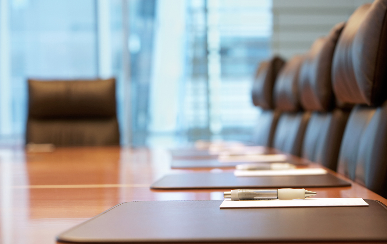 Close up of stationary set up on a meeting table in an empty boardroom.