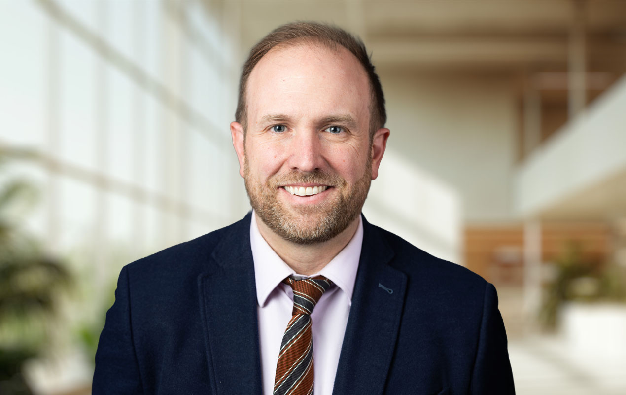 A man in a suit stands in a room.