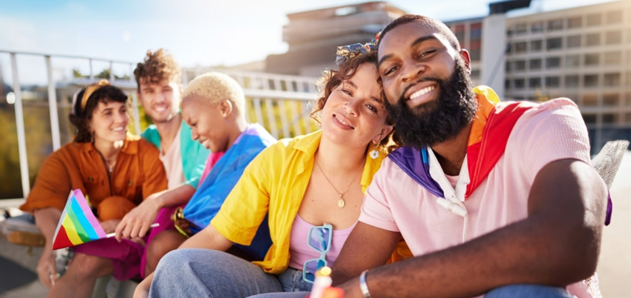 Réunion de jeunes souriants avec des drapeaux LGTBI.